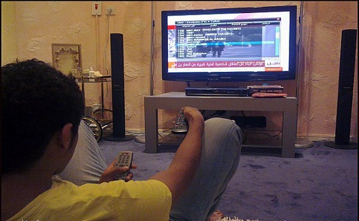 Young Moroccan watching TV. Image for illustration purposes only.